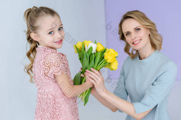 母亲和女儿在3月8日捧着春天的花朵花束