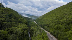在俄罗斯索契的森林里, 沿着蜿蜒的山路行驶的汽车的空中股票照片。人行, 路之旅, 穿越美丽的乡村风光.