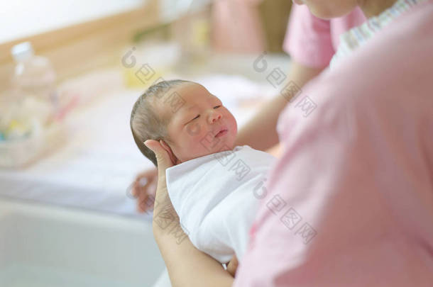 亚洲新生儿沐浴由他妈妈，亲爱的男孩