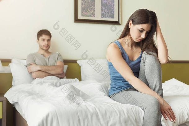 夫妇吵架后坐在床上