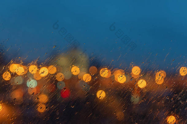 抽象模糊的风景画的背景。 夜景不再聚焦，城市的灯光透过窗户洒下<strong>雨</strong>滴