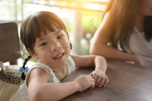 可爱的亚洲女孩坐在咖啡馆