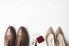 对新娘和新郎鞋, 胸花, 首饰盒和结婚戒指在白色的顶部视图