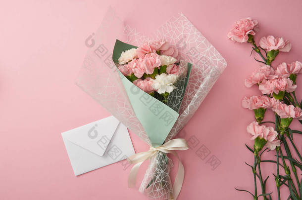 美丽的花束, 粉红色的康乃馨花<strong>和</strong>白色信封隔离在粉红色 