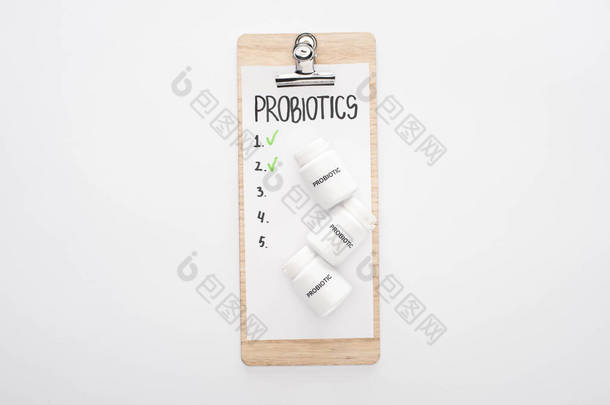 带有抗生素空白列表和白色背景药丸的剪贴板的顶部视图