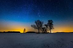 银河和满天星斗的天空，结束冬季风景和遥远的村庄