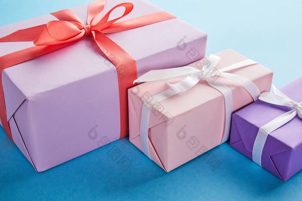 蓝色背景<strong>彩带</strong>和蝴蝶结的彩色礼品盒