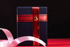 情人节概念中的蓝色礼品盒，装饰有黑色底色的红丝带和红色表面