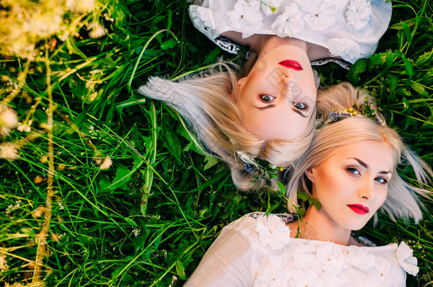 双胞胎姐妹躺在绿色的草地上