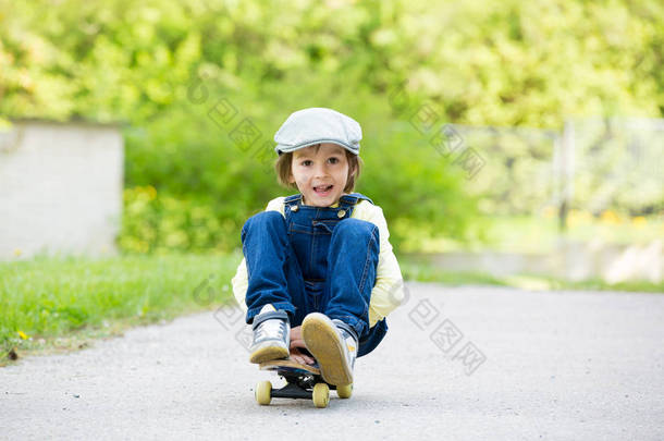 可爱的学龄前儿童，在大街上<strong>玩滑板</strong>