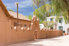 圣佩德罗-德阿塔卡马的沙漠教堂的食物被要求的一个小广场。在一个阳光明媚的日子里, 有十字架和精致的红色粘土栅栏的教堂大门.