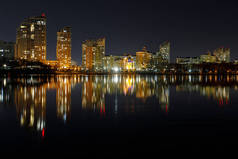 黑暗的城市景观与照明的建筑物与反射在夜间的水
