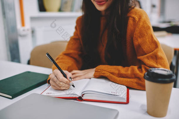 有才华的女<strong>学生</strong>在备课时对记事本做记号的裁剪图像在校园里, 有才华的创意时髦女孩用黑钢笔录制信息