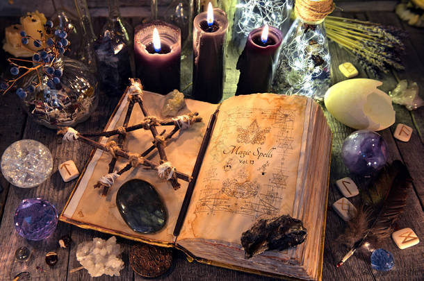 <strong>老</strong>巫婆书与五角星形, 黑蜡烛, 水晶并且礼节对象。神秘的, 深奥的和占卜的概念。没有外国文字, 所有在页上的符号是幻想, 虚构的 