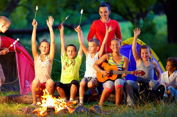 快乐的孩子围绕篝火唱歌