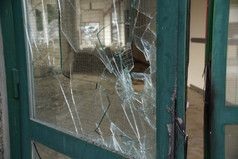 破碎的玻璃门与绿色的金属框架