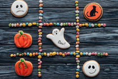 从五颜六色的糖果和怪异的万圣节饼干在木桌上的构图的最高视图 