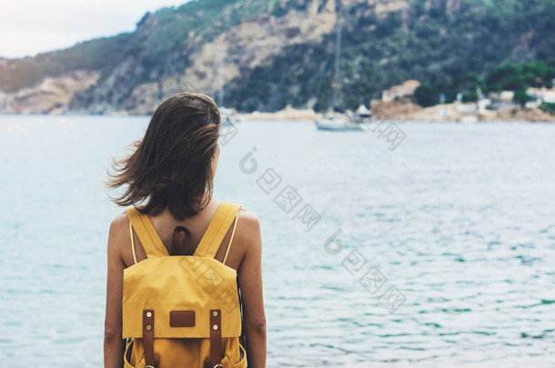 备份视图时髦女孩与砂海岸线在背包上自然景观模拟。对背景的海滩海景和地平线山的旅行者。旅游看在蓝太阳的海洋，夏季放松的生活方式 