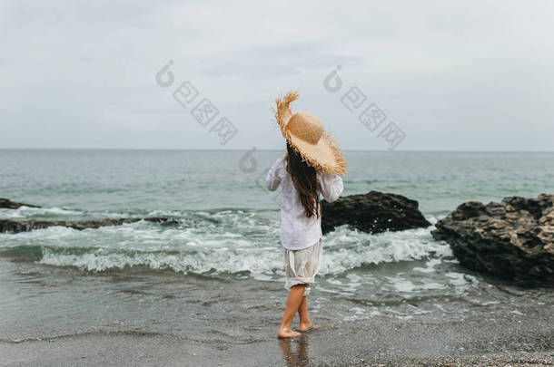 可爱的小女孩在海滩草帽在夏天假期