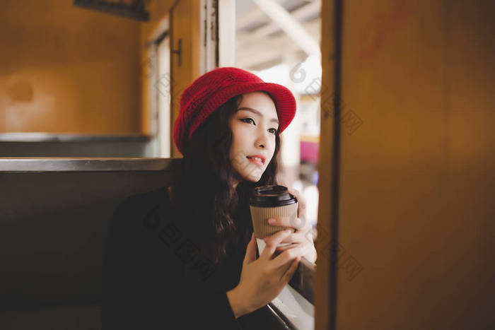 肖像迷人的美丽的旅行女人。迷人的美丽女子是旅游地点或旅游景点的老式火车。华丽的女人看风景和举行一杯咖啡