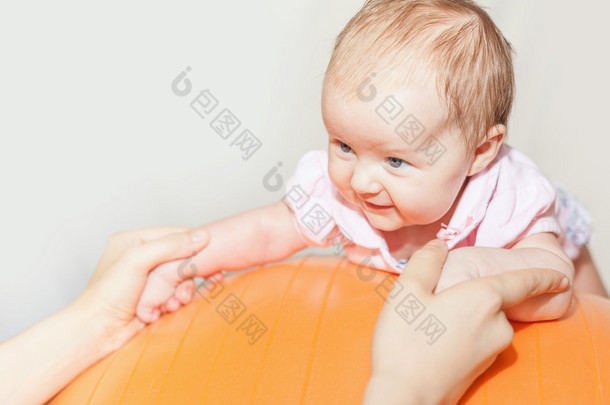 Mom with <strong>happy</strong> baby doing exercises at gymnastic ball