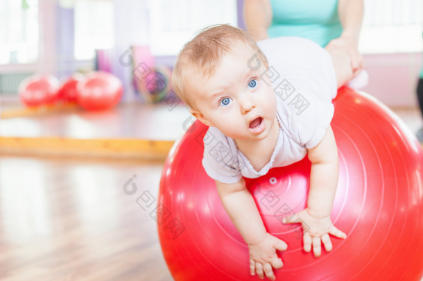 母亲带着快乐的宝贝，做体操球练习