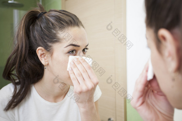 美丽的黑发女人，从她的脸卸妆