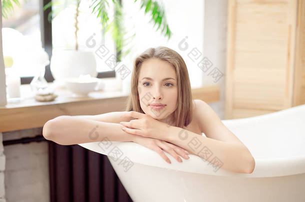 漂亮的女孩在浴缸中休息.