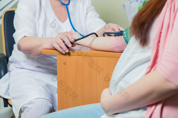 医生测量血压的孕妇在诊所