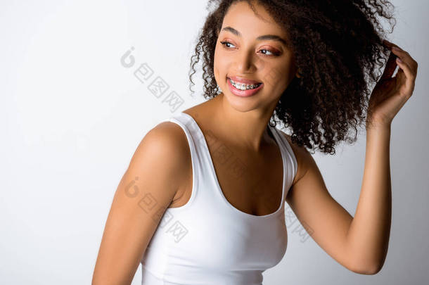 快乐的卷曲非洲裔美国女孩，带着假牙，与灰色隔离
