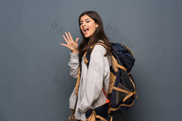 十几岁的旅行者女孩在墙壁计数五<strong>用手指</strong>