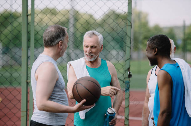 在操场上用<strong>篮球</strong>球的多民族老运动员群