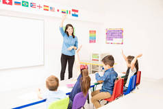 漂亮的拉丁学前教育老师要求学生举手参加课堂