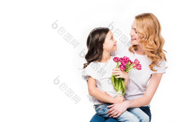 愉快的母亲和小女儿与花束被隔绝的花在白色, 母亲节假日概念