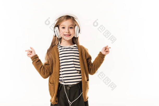微笑小孩子听音乐与耳机隔离在白色