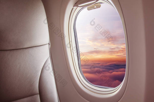 <strong>飞机</strong>内部与窗口视图日落在<strong>云彩</strong>之上。旅行和空运概念