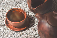 用粘土杯酿造的黑中国普洱茶。茶道陶瓷制品的组成.