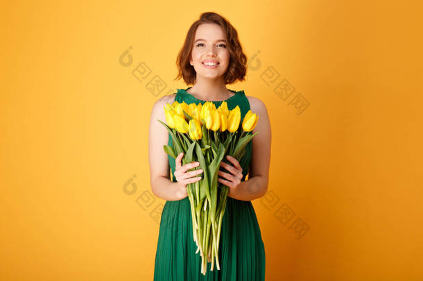 橙色的黄色郁金香花束捧着<strong>微笑</strong>的女人的肖像
