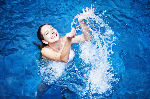 年轻漂亮的女人泼在游泳池中的<strong>水</strong>
