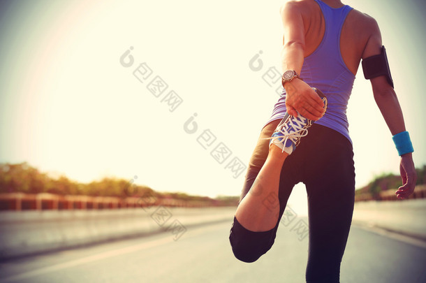 伸展腿部的女跑步运动员