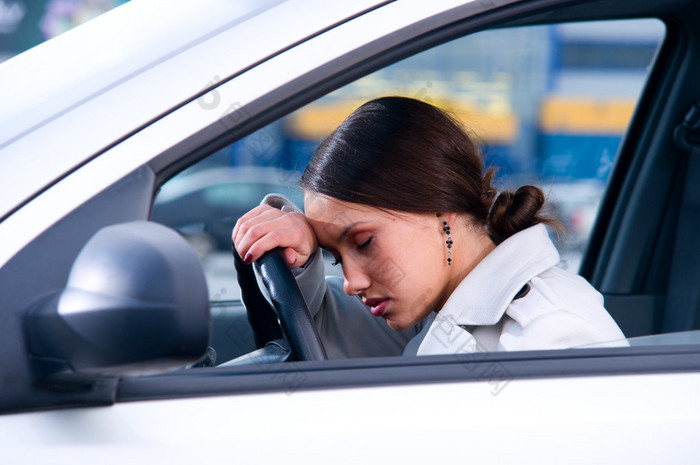 美丽的女人睡在一辆车