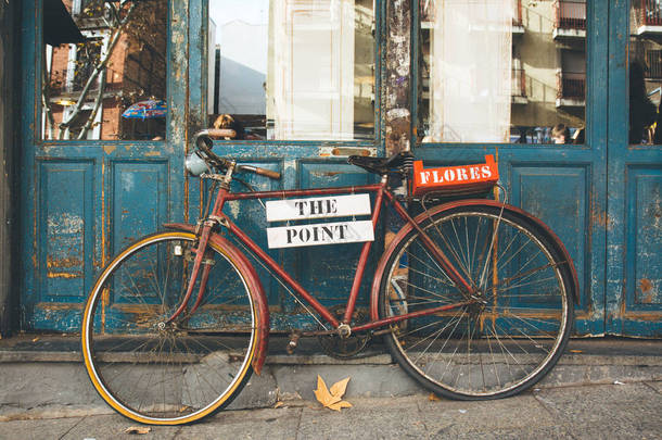 旧的蓝色门上的旧自行车