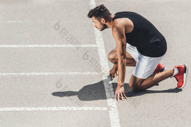 青年男子运动员在跑步<strong>跑道</strong>低启动时的侧面观察 