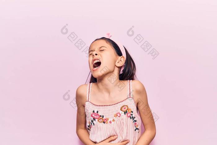 漂亮的小女孩穿着休闲装双手放在肚子上因为