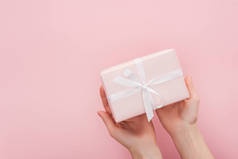 裁剪视图的妇女举行礼品盒隔离粉红色与复制空间