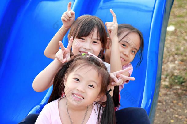三个快乐微笑着孩子们在公园玩
