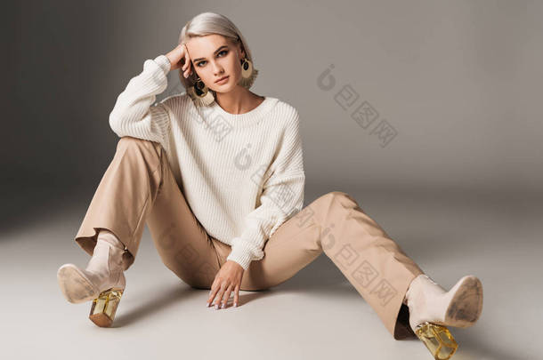 时装模特穿白色毛衣, 米色裤和秋季高跟鞋, 灰色 