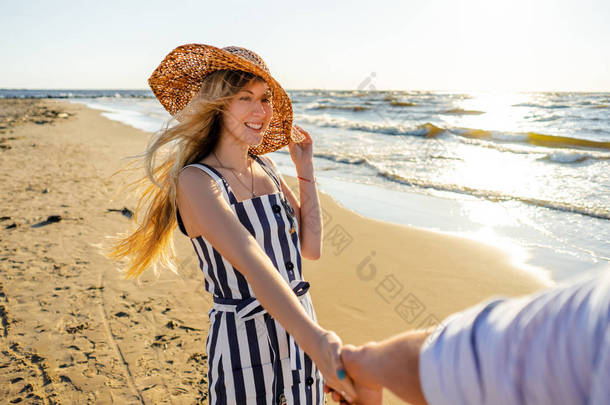 在沙滩上散步时, 微笑的女人抱着<strong>男友</strong>手的部分看法