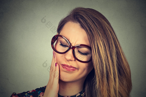  戴眼镜的妇女敏感牙痛冠问题即将从疼痛哭 