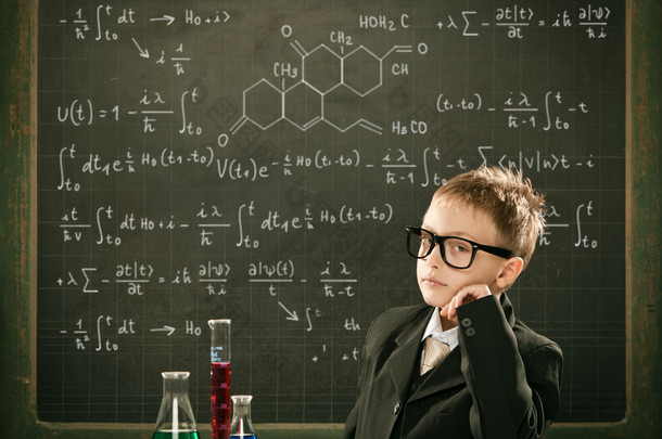 年轻优雅聪明化学学生或科学家严重摆姿势与黑板